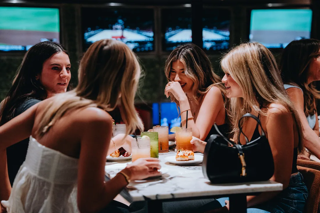 Friends sharing drinks and food at House Rules